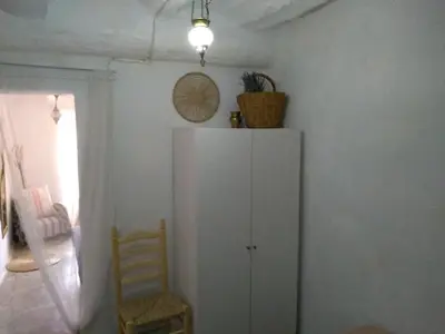 a white cabinet and a chair in a room at CASICA TIA CARMEN in Chulilla