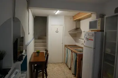a small kitchen with a table and a refrigerator at CASICA TIA CARMEN in Chulilla