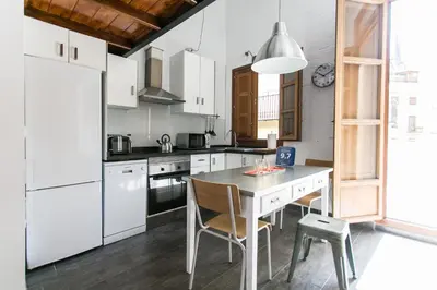 a kitchen with white appliances and a table and chairs at BUBUFLATS / Mercat in Valencia
