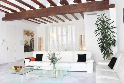 a white living room with a white couch and a glass table at Apartamento Reina Catedral in Valencia