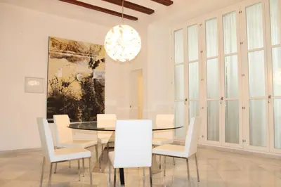 a dining room with a glass table and white chairs at Apartamento Reina Catedral in Valencia