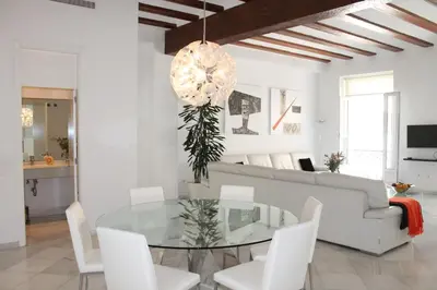 a living room with a glass table and white chairs at Apartamento Reina Catedral in Valencia