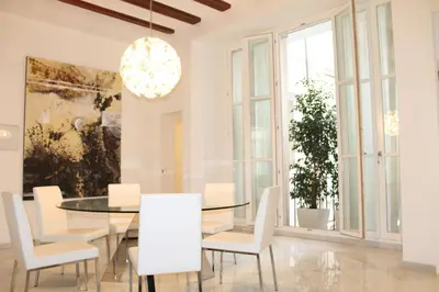 a dining room with a glass table and white chairs at Apartamento Reina Catedral in Valencia