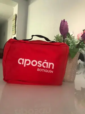 a red bag sitting on a table with flowers at Apto POSEIDON CON PARKING EN EDIFICIO SUBTERRANEO in Cullera