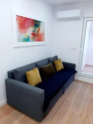 a blue couch in a living room with a painting at UIM Mediterraneo PB Columbretes 12 Wifi in Puerto de Sagunto