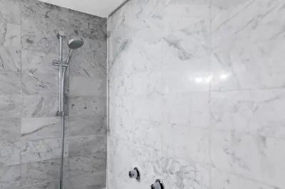 a shower in a bathroom with white marble walls at Loft en el corazón de Valencia in Valencia