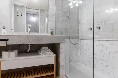 a white bathroom with a shower and a sink at Loft en el corazón de Valencia in Valencia
