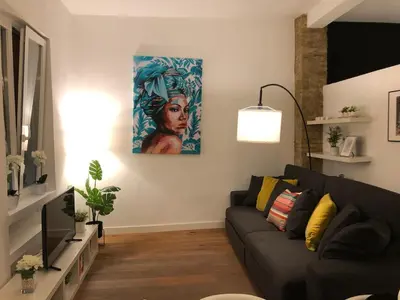 a living room with a couch and a painting on the wall at Impresionante apartamento en Ruzafa al lado del mercado in Valencia