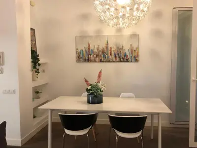 a dining room table with chairs and a painting on the wall at Impresionante apartamento en Ruzafa al lado del mercado in Valencia