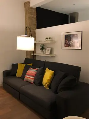 a black couch with yellow pillows in a living room at Impresionante apartamento en Ruzafa al lado del mercado in Valencia