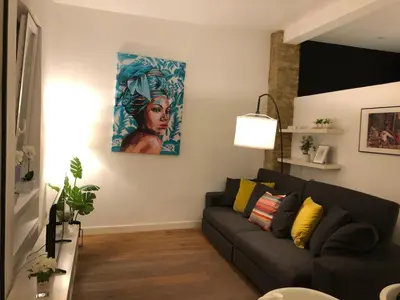 a living room with a couch and a painting on the wall at Impresionante apartamento en Ruzafa al lado del mercado in Valencia