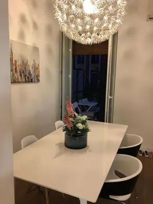 a white dining room table with a vase of flowers on it at Impresionante apartamento en Ruzafa al lado del mercado in Valencia