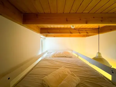 a bed in a room with a wooden ceiling at Duplex al lado de los Jardines del Turia in Valencia