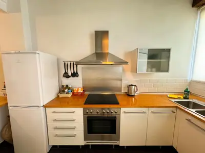 a kitchen with a stove and a white refrigerator at Duplex al lado de los Jardines del Turia in Valencia