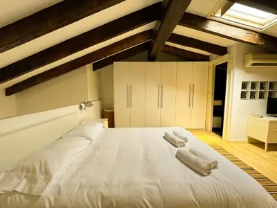 a large white bed in a room with wooden ceilings at Duplex al lado de los Jardines del Turia in Valencia