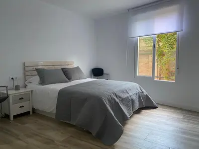 a white bedroom with a bed and a window at Cozy flat in La Petxina B in Valencia