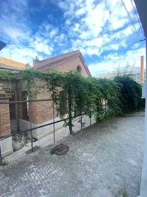 a building with a fence with ivy growing on it at Cozy flat in La Petxina B in Valencia