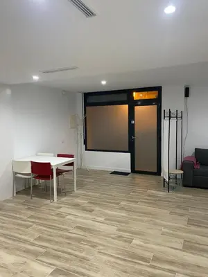 a room with a large screen in a room with a table and chairs at Cozy flat in La Petxina B in Valencia
