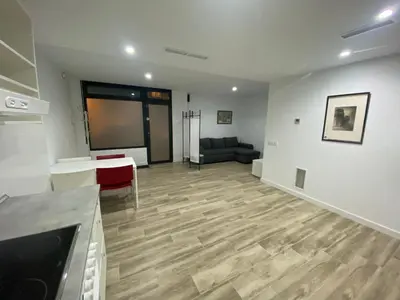 a living room with a couch and a wooden floor at Cozy flat in La Petxina B in Valencia