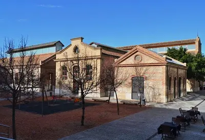 a large brick building with trees in front of it at Cozy flat in La Petxina B in Valencia