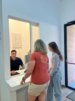 a woman standing at a counter in front of a mirror at Beach & Arts Hostel Valencia in Valencia
