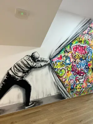 a painting of a man leaning against a wall at Beach & Arts Hostel Valencia in Valencia