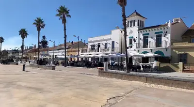 a street with tables and umbrellas in front of a building at Apartamento equipado playa Valencia OnesDeMar in Valencia