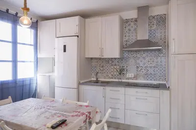 a kitchen with white cabinets and a table with chairs at Benlloch Silence in Valencia