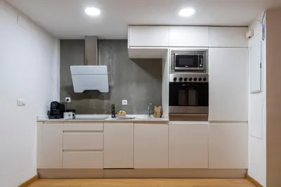 a kitchen with white cabinets and a microwave at Moontels Paseo de Ruzafa in Valencia