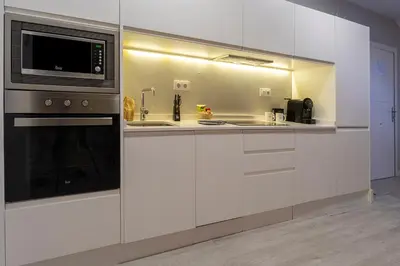 a kitchen with white cabinets and a microwave at Moontels Paseo de Ruzafa in Valencia