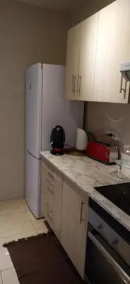 a kitchen with a white refrigerator and white cabinets at City apartment in Valencia
