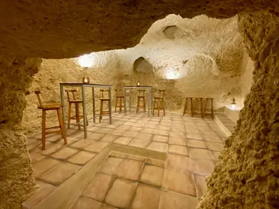 a room with chairs and tables in a cave at VILLA SOL Casa con cueva privada y vistas a la Iglesia in Requena