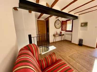 a living room with a couch and a clock on the wall at VILLA SOL Casa con cueva privada y vistas a la Iglesia in Requena