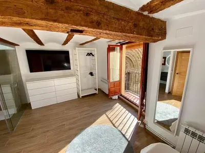 a living room with a television and a large window at VILLA SOL Casa con cueva privada y vistas a la Iglesia in Requena