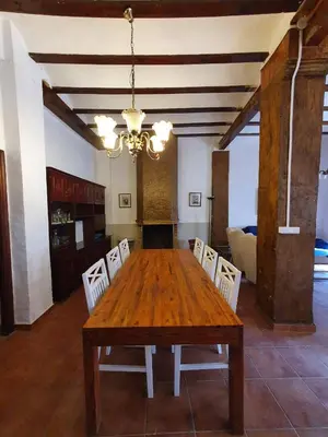 a dining room with a wooden table and chairs at CASA BAUTISTA - ROTGLÀ in Rotglá y Corbera