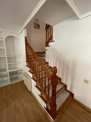 a wooden staircase in a home with white walls at Precioso adosado con parking a 100 metros de la playa in Playa de Mar