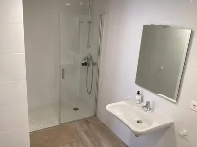a white bathroom with a shower and a sink at Studio Sorolla - Spacious studio near Valencia's beaches in Valencia