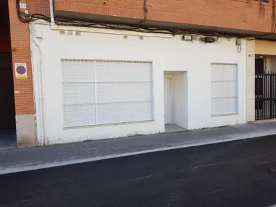 a white building with two garage doors and a street at Studio Sorolla - Spacious studio near Valencia's beaches in Valencia
