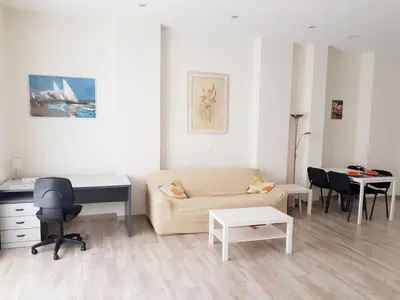 a living room with a couch and a desk at Studio Sorolla - Spacious studio near Valencia's beaches in Valencia