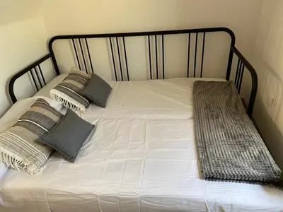 a white bed with pillows and a black frame at Apartamentos Casa Anselmo EL TERRAO in Losa del Obispo
