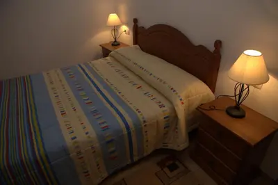 a bedroom with a bed with a lamp on a night stand at Casa Arminda in Benafer