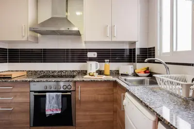 a kitchen with white cabinets and a stove and a sink at Apartamentos FV Flats Valencia - Mestalla 7 in Valencia