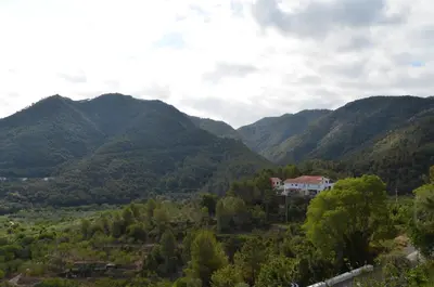 a house in the middle of a valley with mountains at Casa el Castell in Eslida