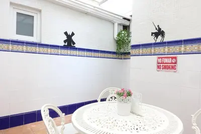 a white table with a vase and flowers on it at Best Valencia Beach Rooms-Shared Flat in Valencia