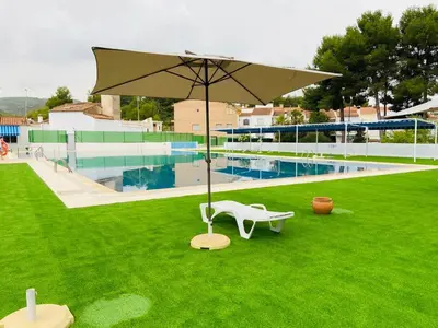 a white umbrella and a bench and a pool at Casa Mayor in Tous