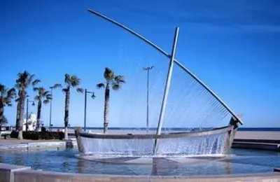 a boat sitting in the water near the beach at BEACH VALENCIA LUXURY A40-13 Apartment with terrace and sea views in Valencia