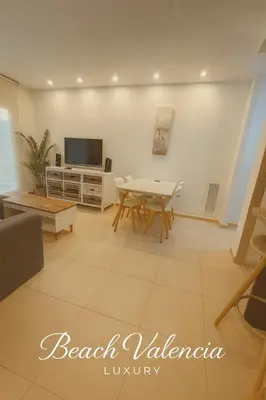 a living room with a table and a tv at BEACH VALENCIA LUXURY A40-13 Apartment with terrace and sea views in Valencia