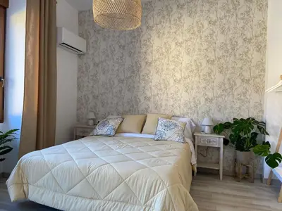 a bedroom with a white bed and two tables at Apartamento Casa Anselmo La cambra in Losa del Obispo