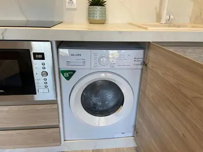 a washing machine in a kitchen under a counter at Apartamento Casa Anselmo La cambra in Losa del Obispo