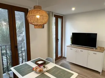 a living room with a table and a television and a chandelier at Apartamentos LOSA RURAL in Losa del Obispo